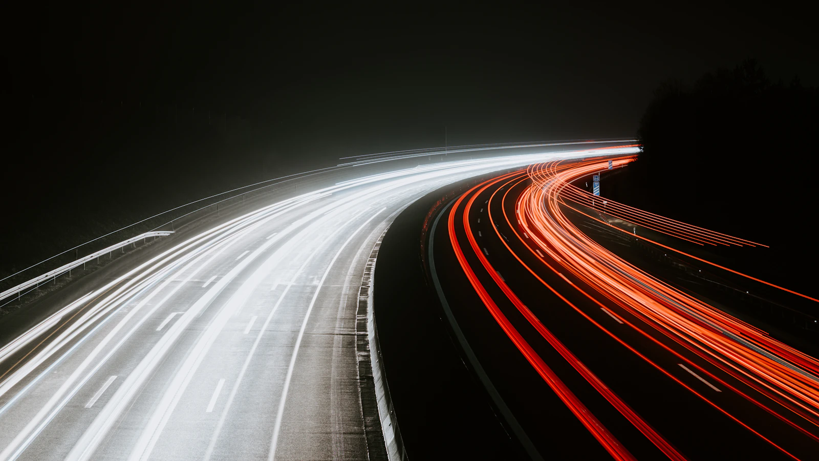 Long-exposure light trails of fast-moving traffic at night, representing a faster website