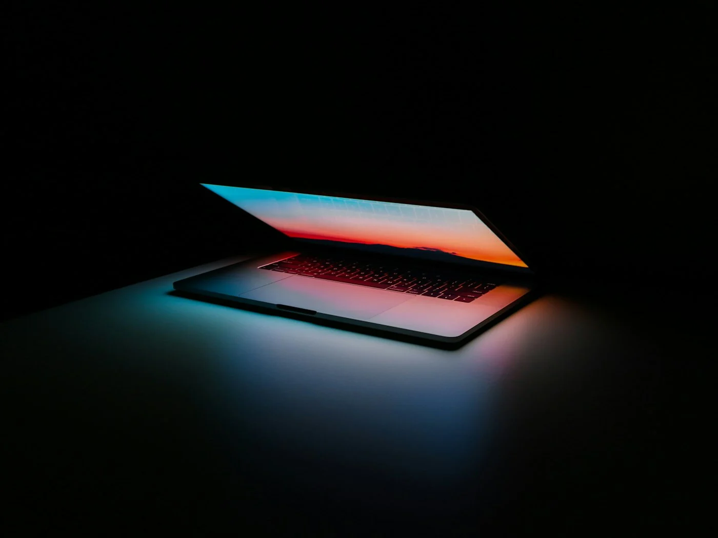 Laptop glowing in a dark room